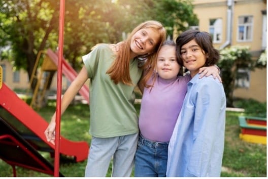 Three kids standing together outdoors with their arms around each other